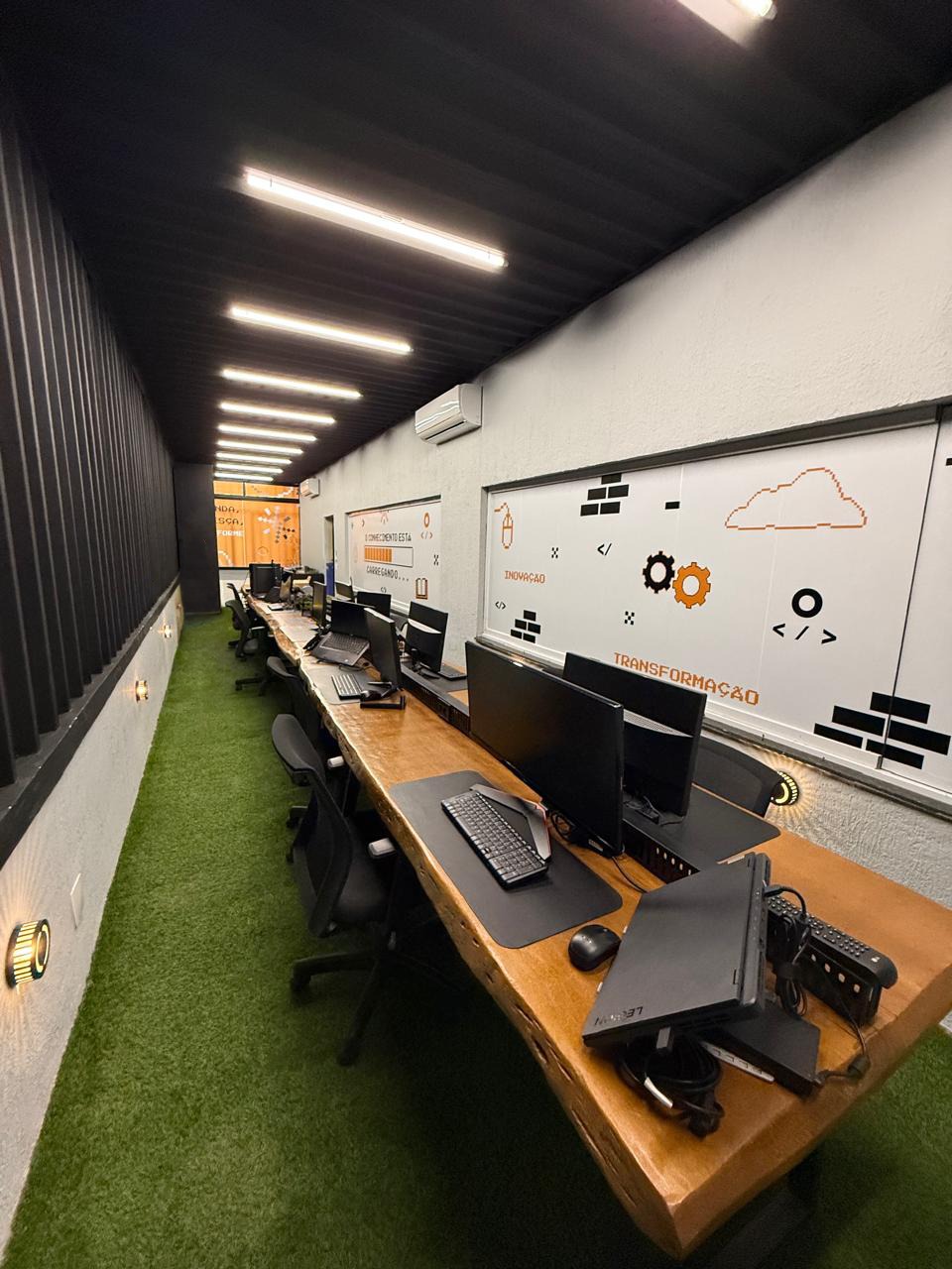 Vista geral do laboratório CodeLAB com bancadas e workstations