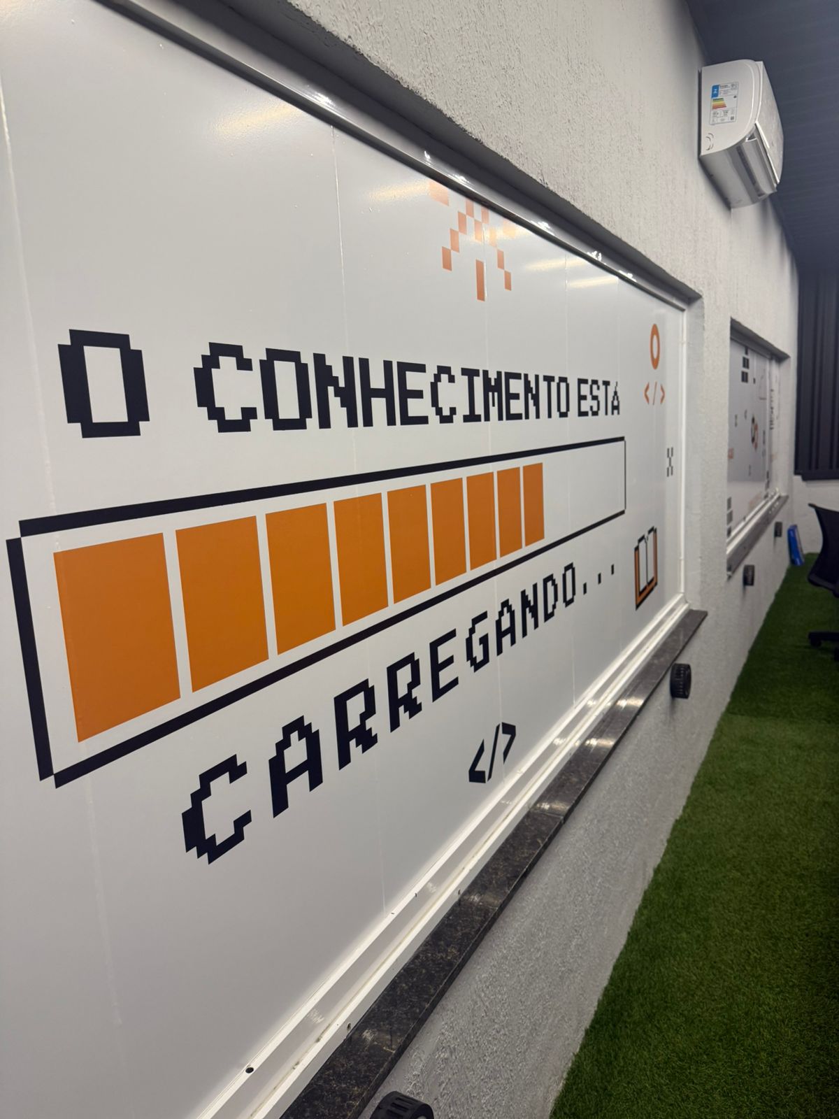 Painel 'O conhecimento está carregando' decorando o espaço